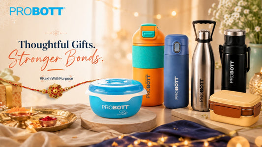 PROBOTT Rakhi gift collection featuring reusable steel bottles, an insulated flask, lunchbox and PROBOTT Lite container arranged with festive Indian décor, a rakhi, diya and gift elements.